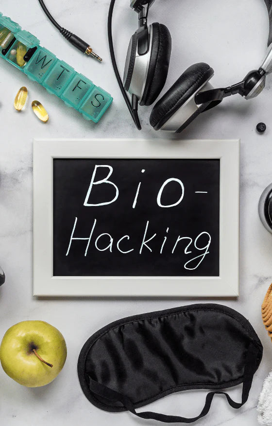 bio hacking sign with headphones next to it, supplements, an apple, eye shades